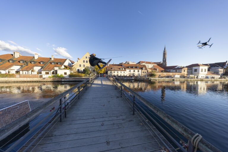 Droheboardin in Landshut. Dominik Gührs überspringt an einer Drohne hängend eine Isarbrücke auf einem Wakeboard gezogen von einer Drohne. Foto: Starelation